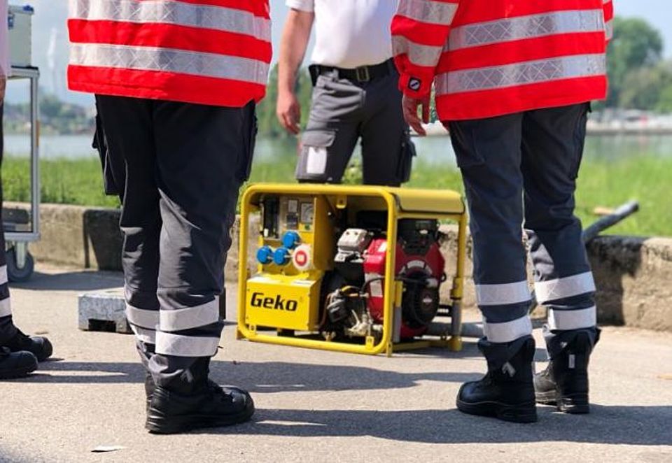 2 Eisatzkräfte vor einem Notstromaggregat